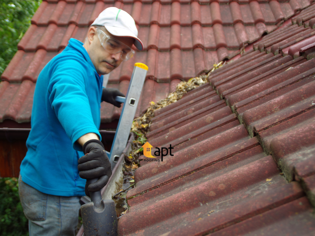Roofing professional inspecting damaged concrete roof tiles and ridge capping to assess whether repairs or restoration are needed